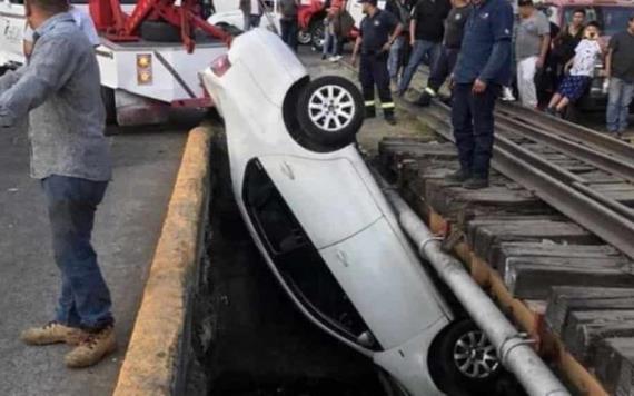 Auto cae a canal de aguas negras