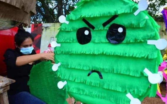 Foto del día: Mujer realiza piñatas del coronavirus en la Deportiva