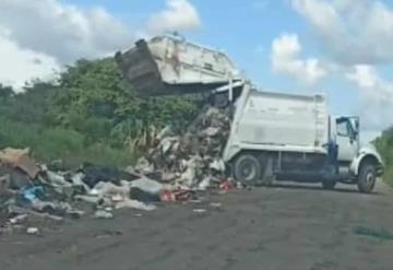 Camión recolector descarga los desechos a orilla de carretera