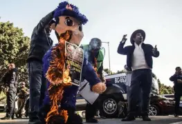 Activistas en apoyo a migrantes queman piñata de policía en protesta por abusos en Tijuana