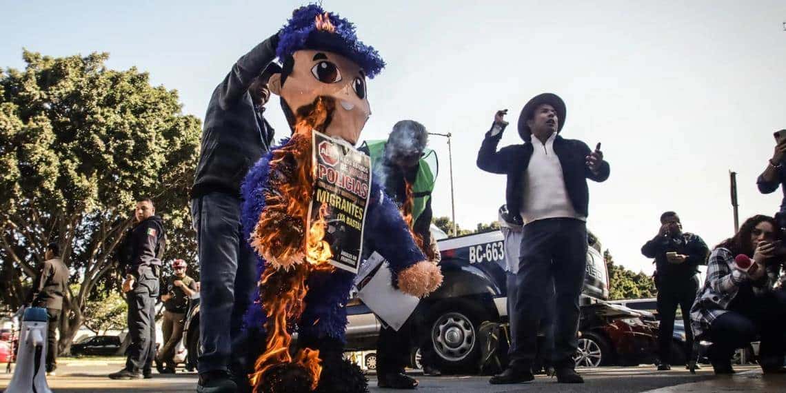 Activistas en apoyo a migrantes queman piñata de policía en protesta por abusos en Tijuana